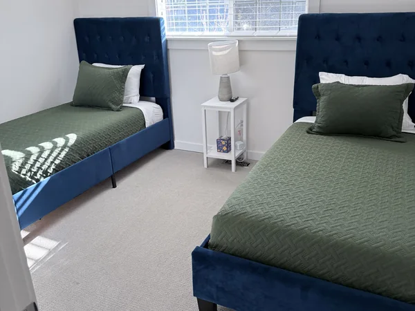 Twin bedroom cleaned with beds, carpet, and surfaces reset